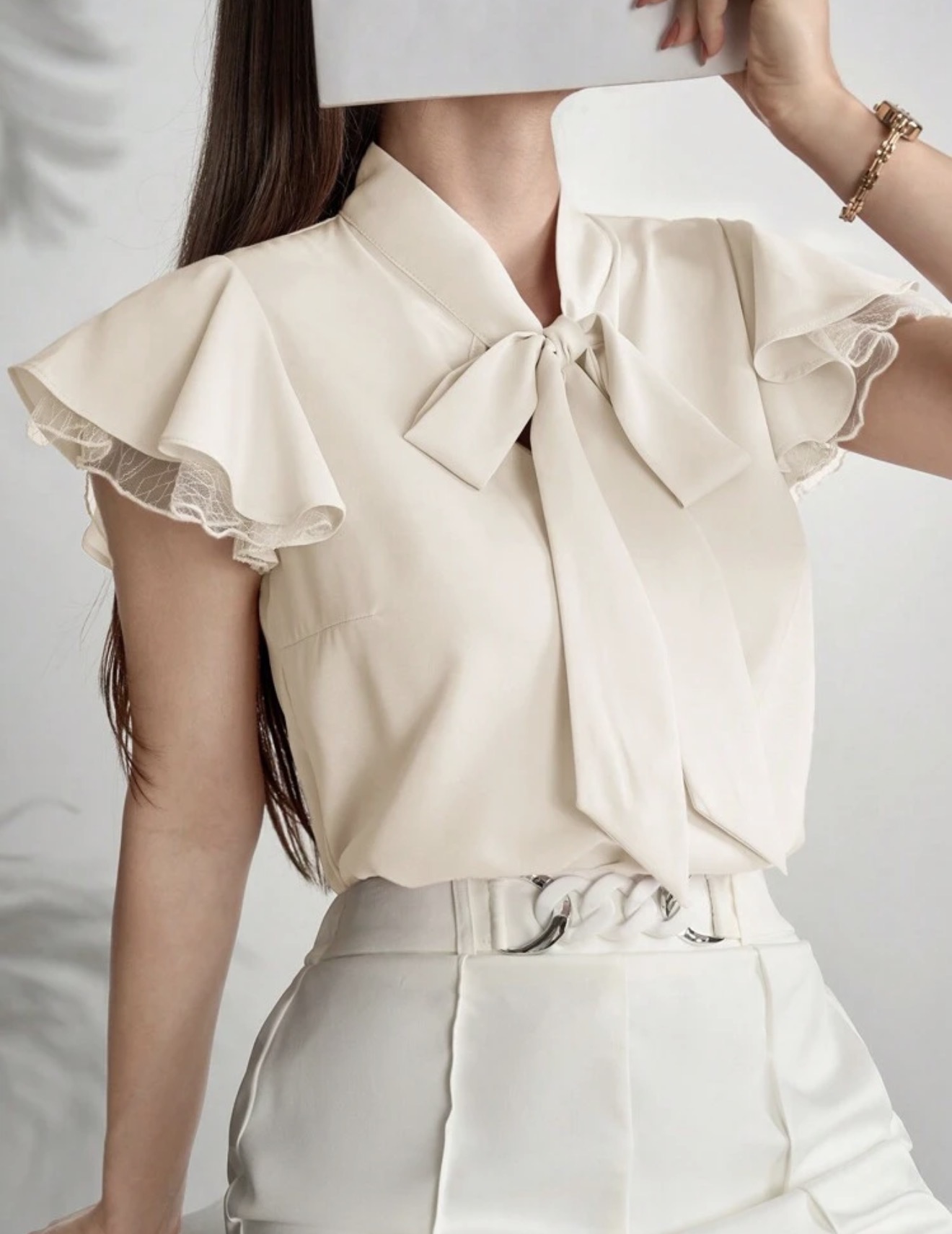 Blusa elegante de mujer con cuello de corbata y mangas con volantes de unicolor